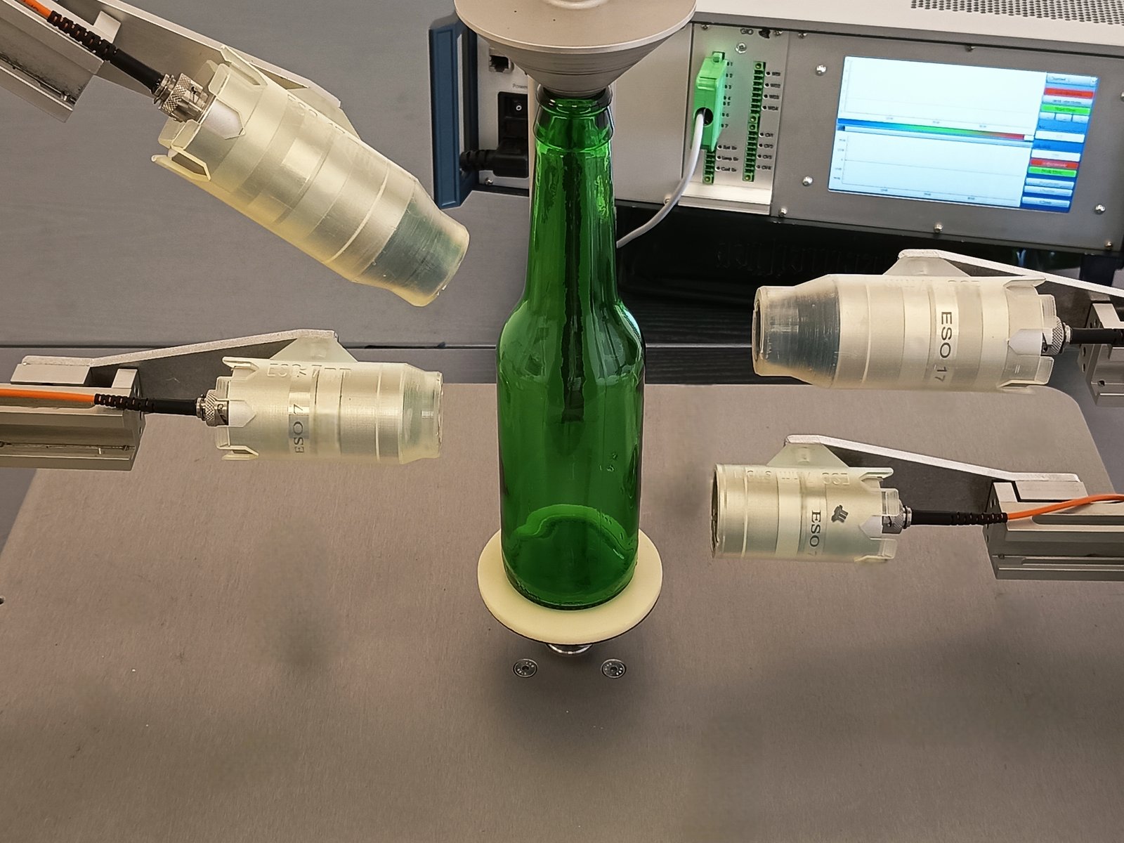 Vier ESO-Messköpfe an einer Glasflasche auf der Rotierstation